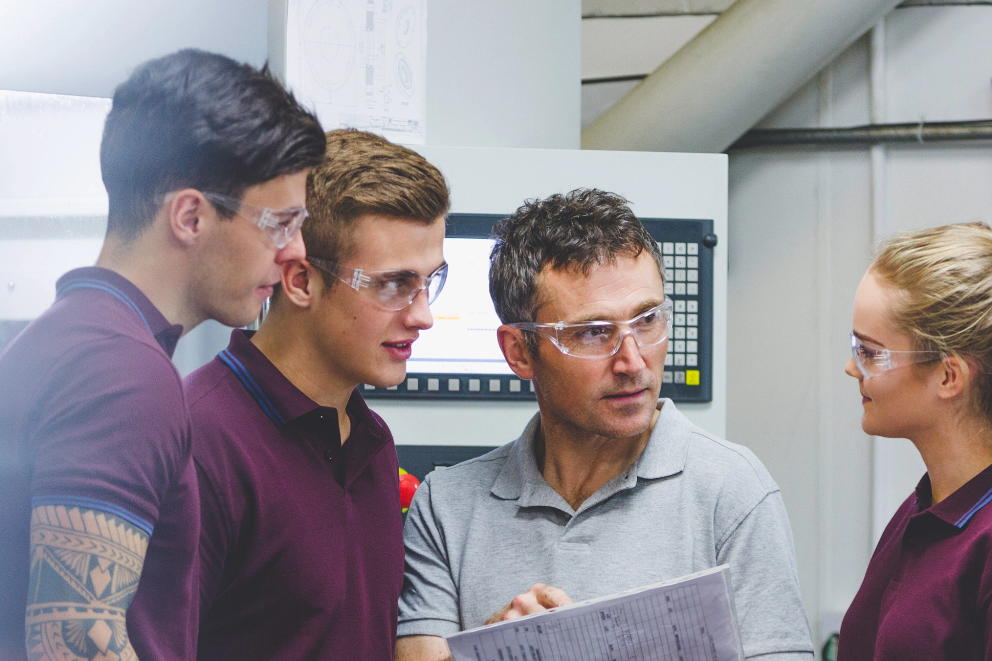 Ausbilder mit drei Auszubildenden