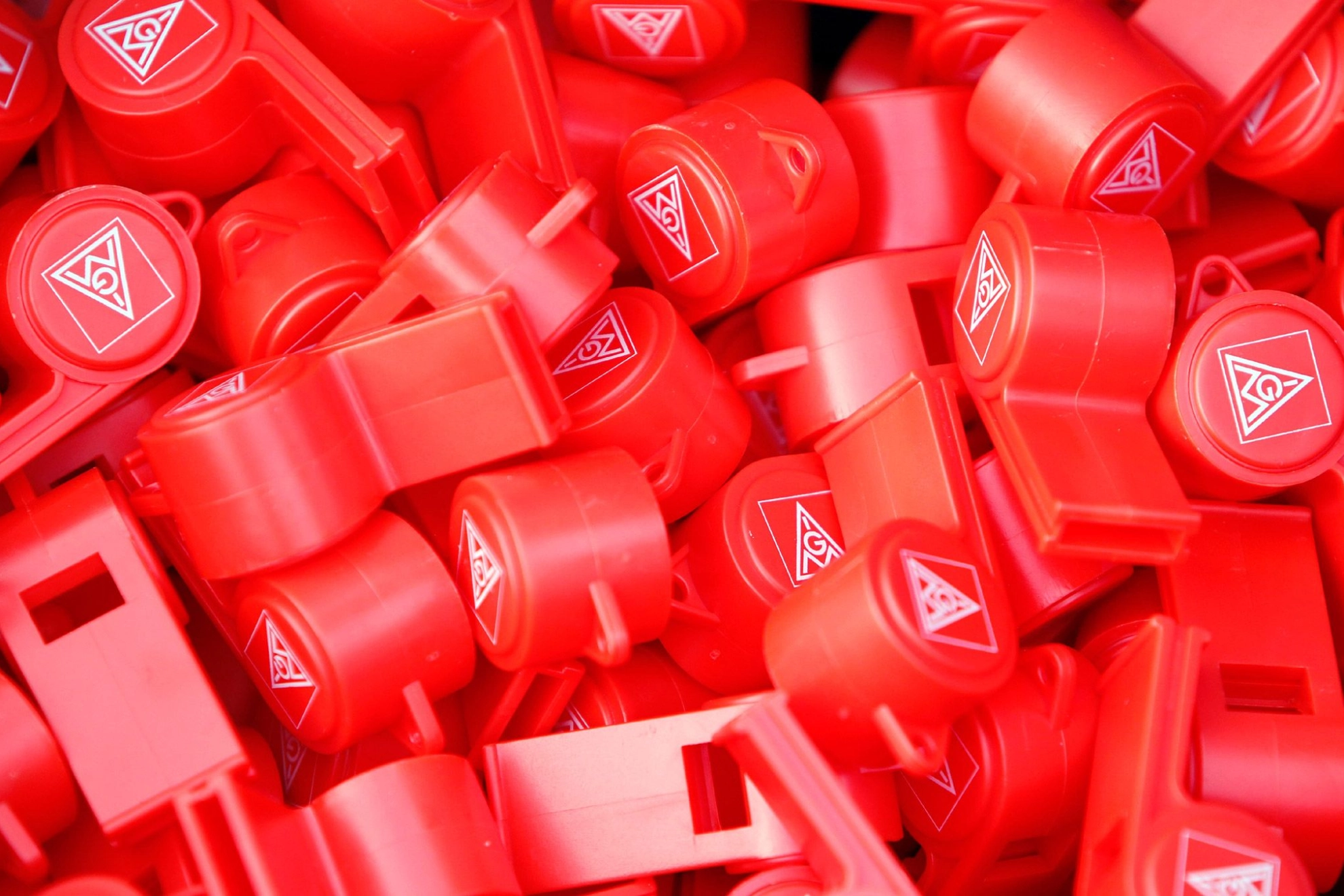 Viele rote Trillerpfeifen mit dem Logo der IG Metall.